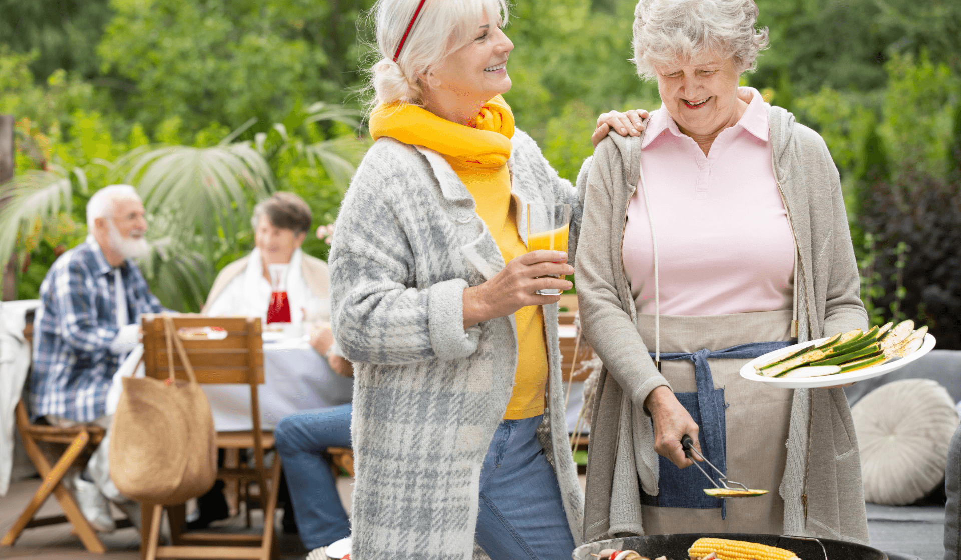 senior citizens enjoying a barbecue outside.